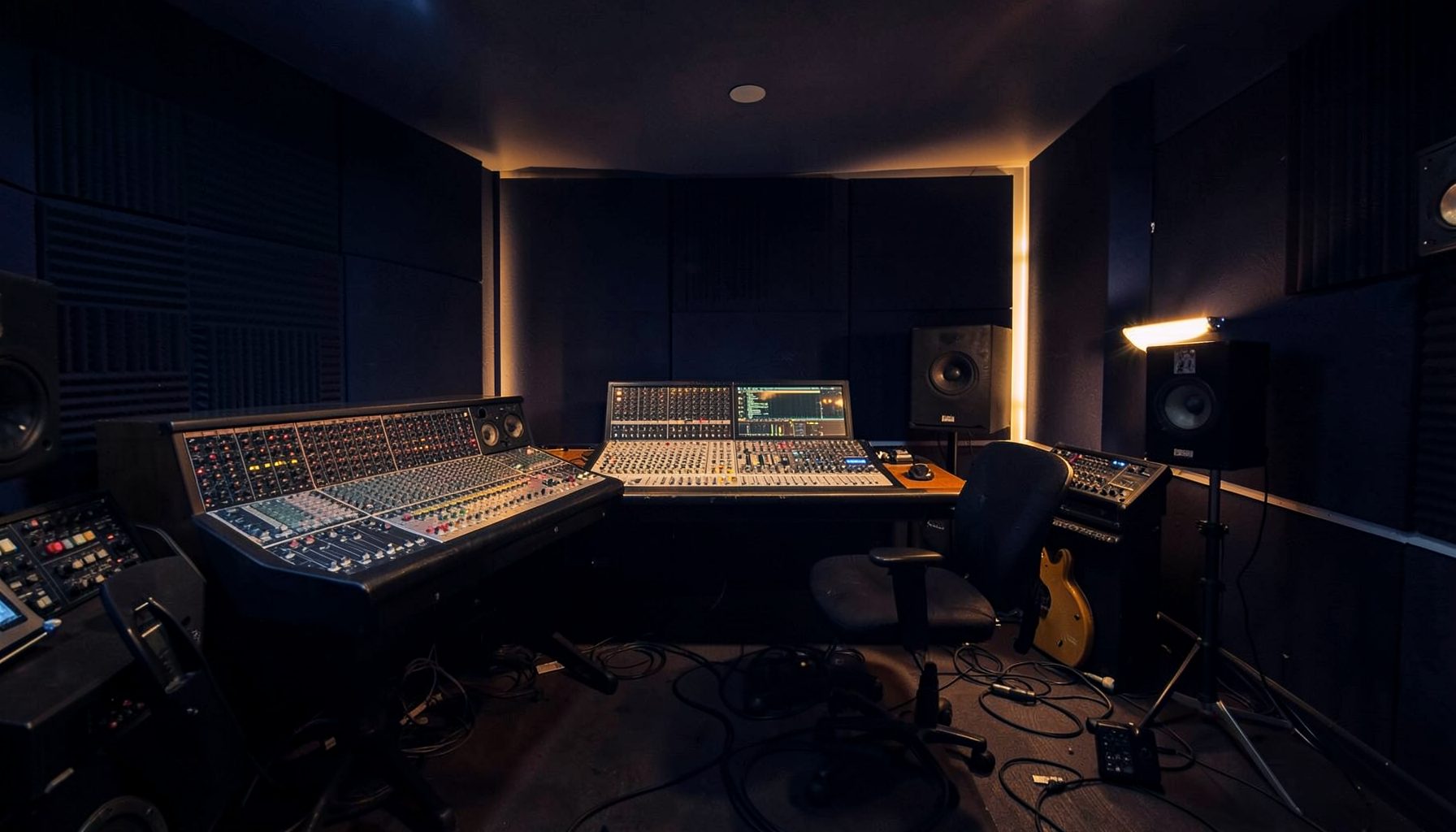 A recording studio interior with deep navy and warm amber lighting, evoking a creative music atmosphere